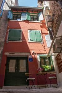 a building with two chairs in front of it at House Corte dei Matte' in Rovinj