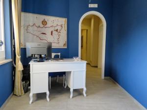 een wit bureau met een computer op een blauwe muur bij Catria in Favignana