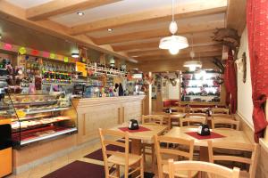 un restaurante con mesas y sillas de madera y una barra en Rifugio Fedaia, en Malga Ciapela