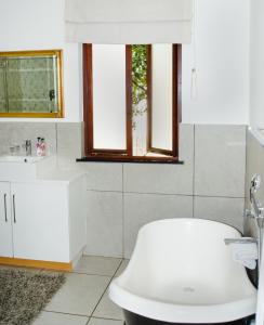 Un baño con un inodoro blanco y un lavabo. en Gardenia Boutique Hotel, en Johannesburgo