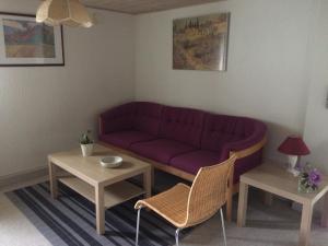 salon z fioletową kanapą i dwoma stołami w obiekcie Dalsgaard w mieście Vojens
