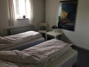 a bedroom with two beds and a picture on the wall at Dalsgaard in Vojens