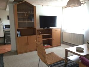 ein Wohnzimmer mit einem TV und einem Entertainment-Center in der Unterkunft Dalsgaard in Vojens