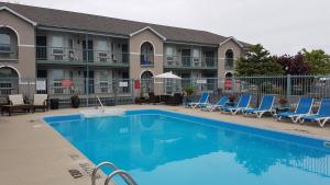 a swimming pool with lounge chairs and a hotel at Lakeview Resort Motel in Wasaga Beach