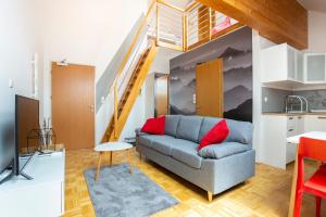 a living room with a couch and a staircase at Krona Apartments in Bovec