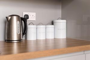 a row of white coffee cups sitting on a counter at The Home Street Residence in Edinburgh