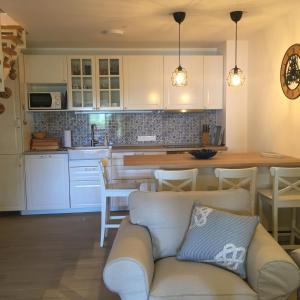 a living room with a couch and a kitchen at Apartment Behin in Martinšćica