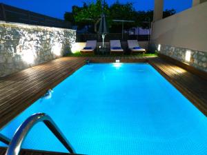una piscina al aire libre por la noche con terraza y sillas en Sunrise Residence en Koxaré
