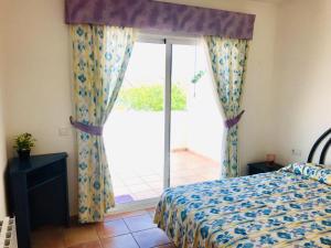 sypialnia z łóżkiem i dużym oknem w obiekcie Casa de familia w mieście Calpe