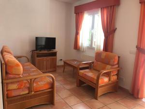 salon z dwoma krzesłami i telewizorem w obiekcie Casa de familia w mieście Calpe