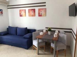ein Wohnzimmer mit einer blauen Couch und einem Tisch in der Unterkunft VILLA DIVNA in Labin