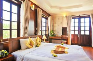 Postel nebo postele na pokoji v ubytování Ky Hoa Hotel Da Lat + 37 fotografií