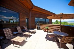 un patio con sillas, mesas y una sombrilla en Carson Valley Motor Lodge and Extended Stay en Minden
