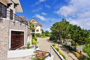 a house with a balcony and flowers on a street at Ky Hoa Hotel Da Lat in Da Lat