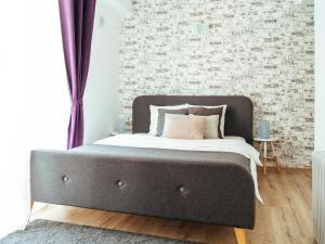 een bed in een slaapkamer met een bakstenen muur bij Tonitza Old Town - Double Studio in Boekarest