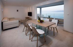 ein Wohnzimmer mit einem Tisch, Stühlen und einem Sofa in der Unterkunft Apartments Vela Sollis in Marusici 