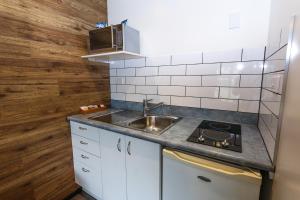 uma pequena cozinha com um lavatório e um fogão em New Plymouth TOP 10 Holiday Park em New Plymouth