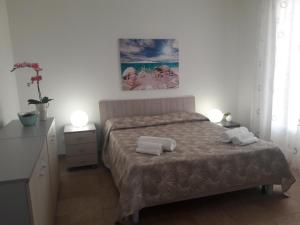ein Schlafzimmer mit einem Bett mit zwei Handtüchern darauf in der Unterkunft Micalice's Sea House in Ognina