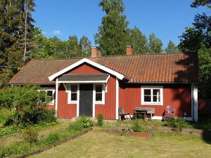 ein rotes Haus mit einem Tisch und Stühlen im Hof in der Unterkunft WESTERQVARN in Mölntorp