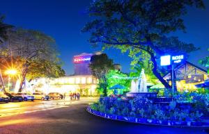 a city street at night with a fountain at Ky Hoa Hotel Ho Chi Minh in Ho Chi Minh City