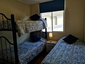 two bunk beds in a room with a window at Condominio Reino de Italia, Serena in La Serena