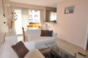 een woonkamer met een witte bank en een tafel bij Cosy One-Bedroom Apartment -StayInAntibes- Le Cosy in Antibes