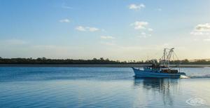 a boat sitting in the middle of a body of water at Ballina Colonial Motel in Ballina +18 photos