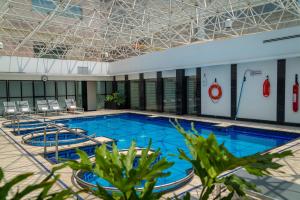 墨西哥城的住宿－墨西哥巴塞羅雷福瑪酒店，一个带椅子和天花板的大型游泳池