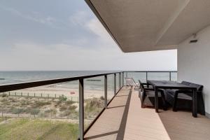 balkon ze stołem i krzesłami oraz plażą w obiekcie Floryda Gardenia Seaside w Dziwnowie