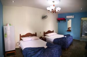 two beds in a room with blue walls at Hostal Vista Hermosa Trinidad in Trinidad
