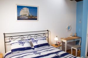 a bedroom with a bed with blue and white pillows at House Corte dei Matte' in Rovinj