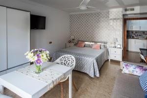 Un dormitorio con una cama y una mesa con flores. en Suite Mirando al Guadiana, en Ayamonte