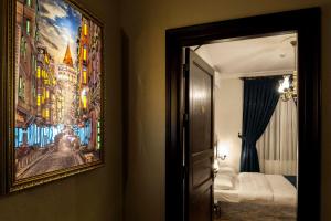 een slaapkamer met een schilderij aan de muur en een spiegel bij Element Garden in Istanbul