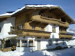 a large wooden building with snow on it at Landhaus Aschaber in Westendorf