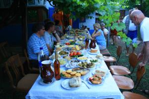 eine lange Tafel mit Speisen, um die herum Menschen saßen in der Unterkunft Vila Dora in Japca