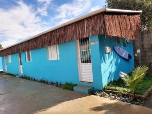 een blauw huis met een rieten dak bij Chales Bora Bora - Boraceia in Boracéia
