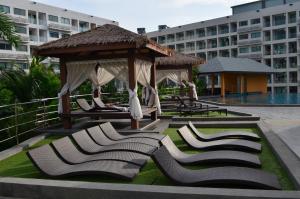 un gazebo con sedie a sdraio di fronte a un edificio di Maldives Laguna Beach Resort 3 a Jomtien Beach