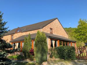 ein Backsteinhaus mit Bäumen davor in der Unterkunft Villa Agni in Barvaux