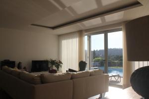 uma sala de estar com um sofá branco e uma grande janela em Manuel Tiago Pereira em Braga