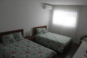 1 dormitorio con 2 camas y ventana en Manuel Tiago Pereira, en Braga