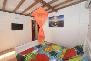 Habitación con cama con cortina naranja en padjembel, en Lamentin