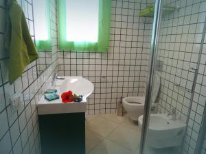 uma casa de banho com um lavatório e um WC em Arcupintau em Villasimius