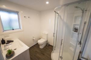 a bathroom with a shower and a toilet and a sink at Tasman Holiday Parks - Te Anau in Te Anau