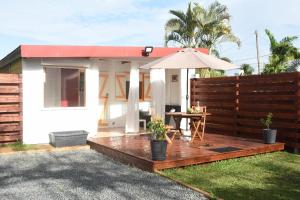 a house with a wooden deck with an umbrella at padjembel in Lamentin