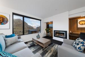 un soggiorno con divano e camino di Coronet Apartment, Complete comfort and views a Queenstown