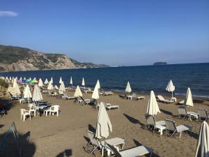 a bunch of chairs and umbrellas on a beach at Summer Studio - Zakynthos!! in Argassi