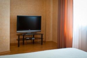 una televisione seduta su un tavolo in una camera da letto di Park Hotel Bogorodsk a Bogorodsk