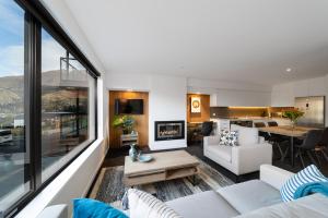 un soggiorno con mobili bianchi e una grande finestra di Coronet Apartment, Complete comfort and views a Queenstown