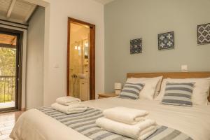 1 dormitorio con 1 cama con toallas en Golden Evelyn, en Agia Paraskevi
