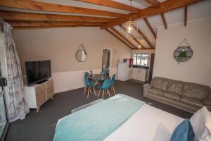 a bedroom with a bed and a table and a couch at Tasman Holiday Parks - Te Anau in Te Anau